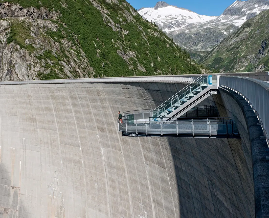 Wir blicken auf den sogenannten Airwalk. Diese freischwebende Vorrichtung ist direkt an der Staumauer in Malta montiert. Hier können Interessierte angstfrei in die Tiefe blicken