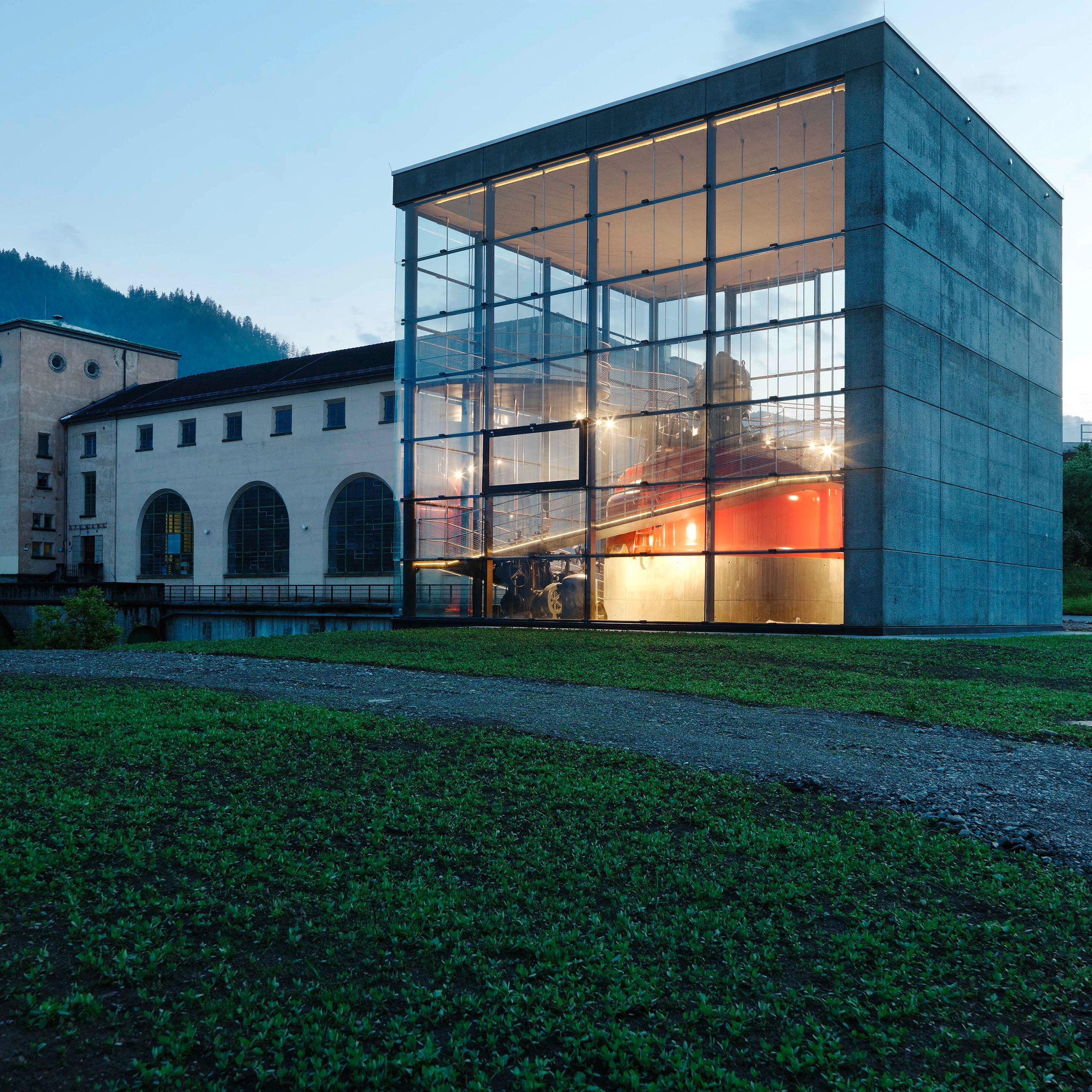A view of the Pernegg show turbine at dusk. The marvellous red turbine can be seen illuminated through a glass construction.