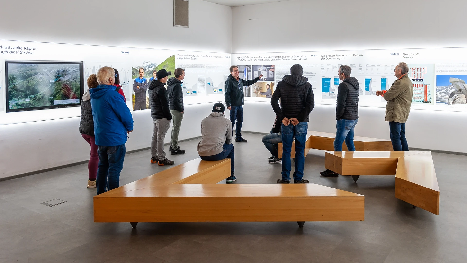 Wir befinden uns im Inneren des Informationszentrums in Kaprun. Einige interessierte haben sich zusammengefunden und höhen einen Führer zu.