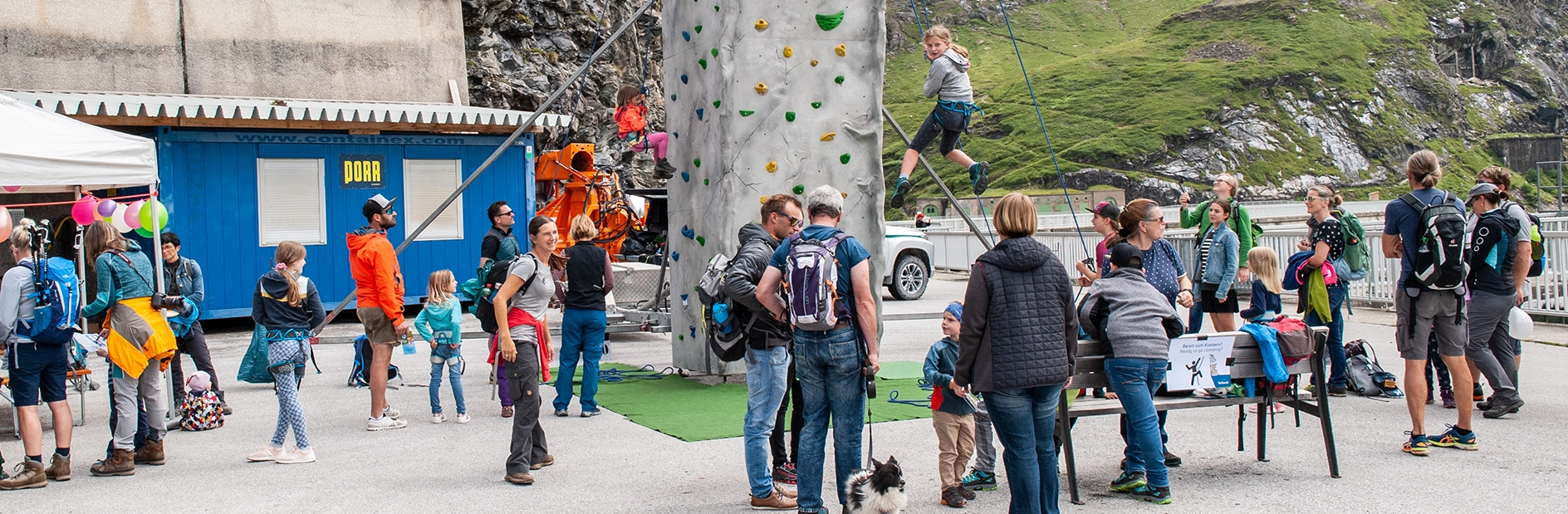 The picture was taken during the Stomi children's festival. In the center we see a small climbing wall for the little ones. It is surrounded by numerous families.