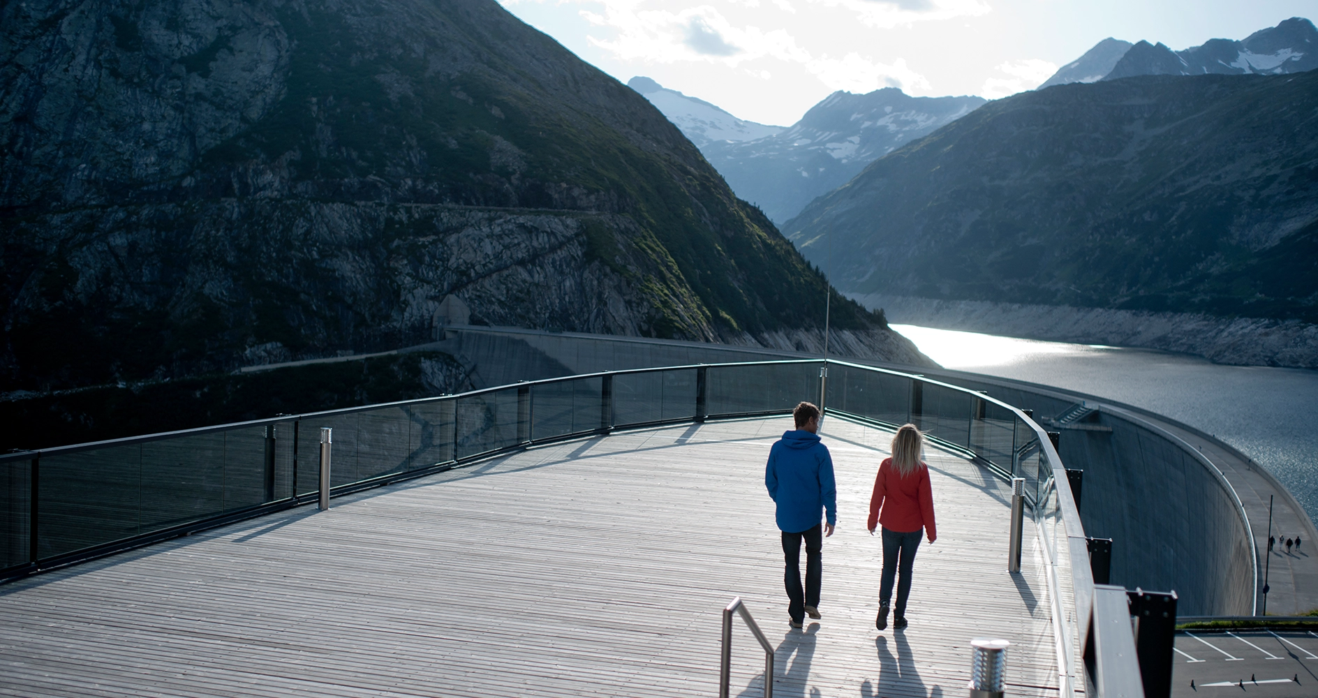 Wir sehen ein Pärchen auf der Panoramaterrasse beim Berghotel Malta. Sie blicken über den Stausee.